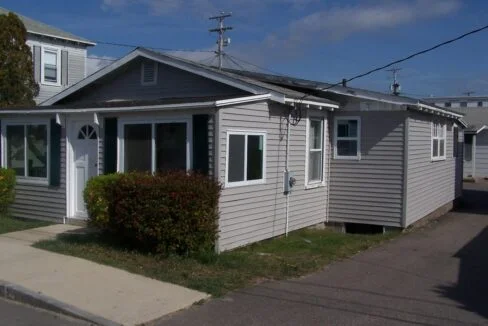 a gray house with a white door and windows.