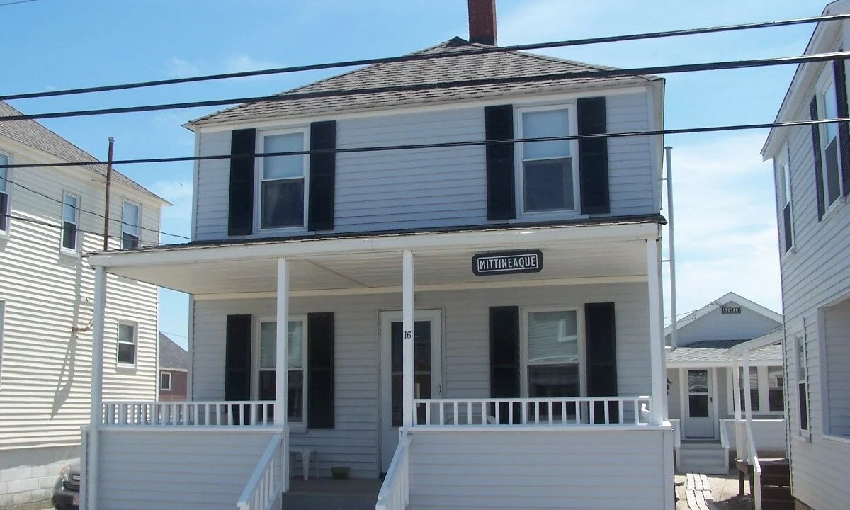 a white two story house with black shutters.