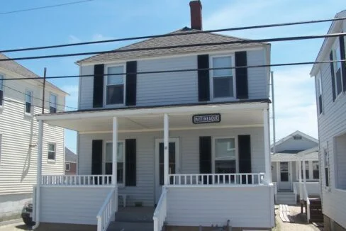 a white two story house with black shutters.