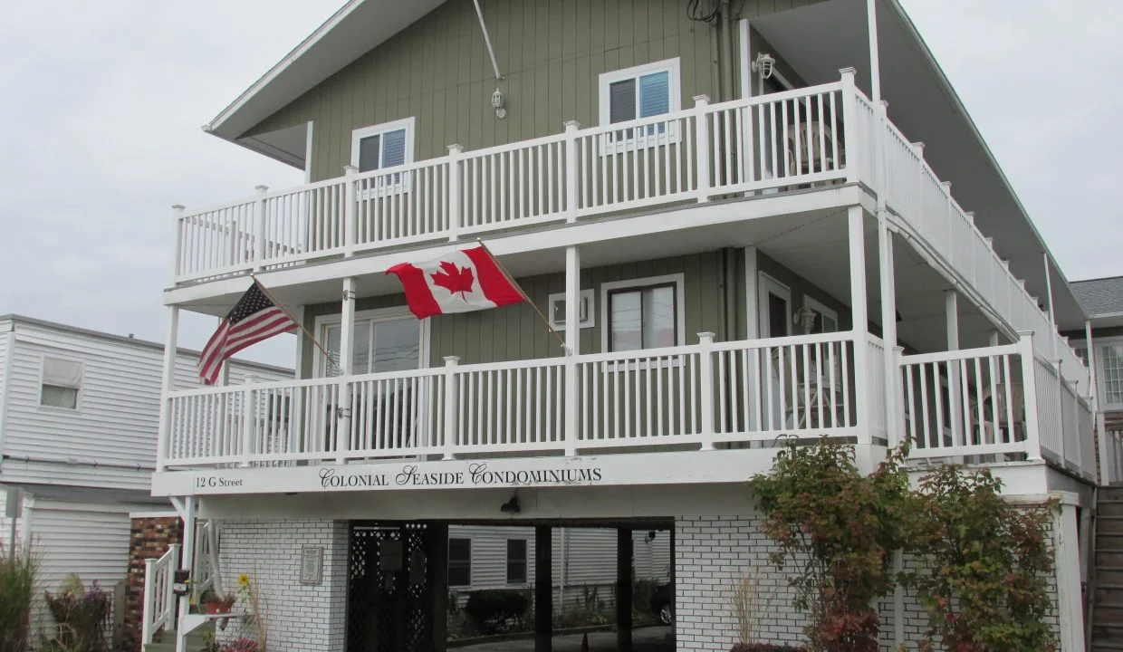 a two story building with a canadian flag on the balcony.