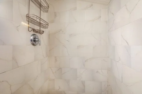 a bathroom with a shower head and a towel rack.