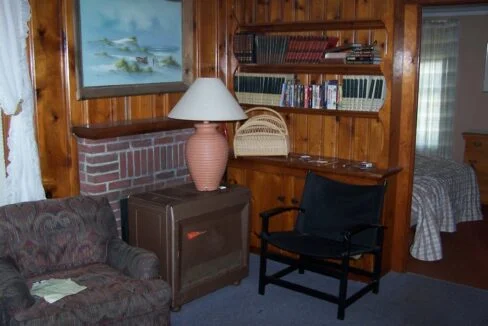 a living room with a chair and a lamp.