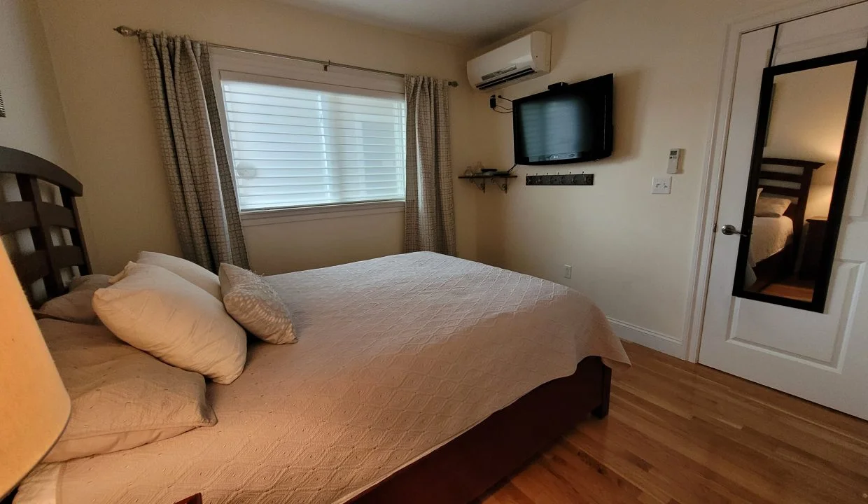 a bedroom with a large bed and a flat screen tv.