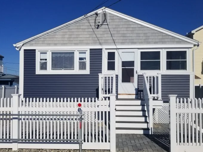 a house with a white picket fence in front of it.