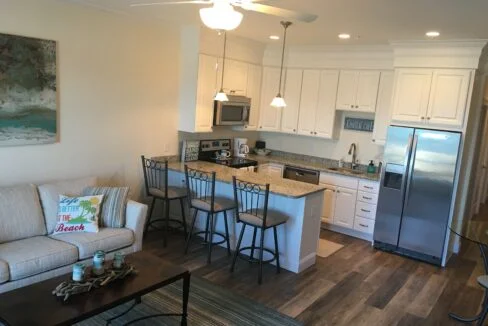 a living room with a couch a table and a refrigerator.