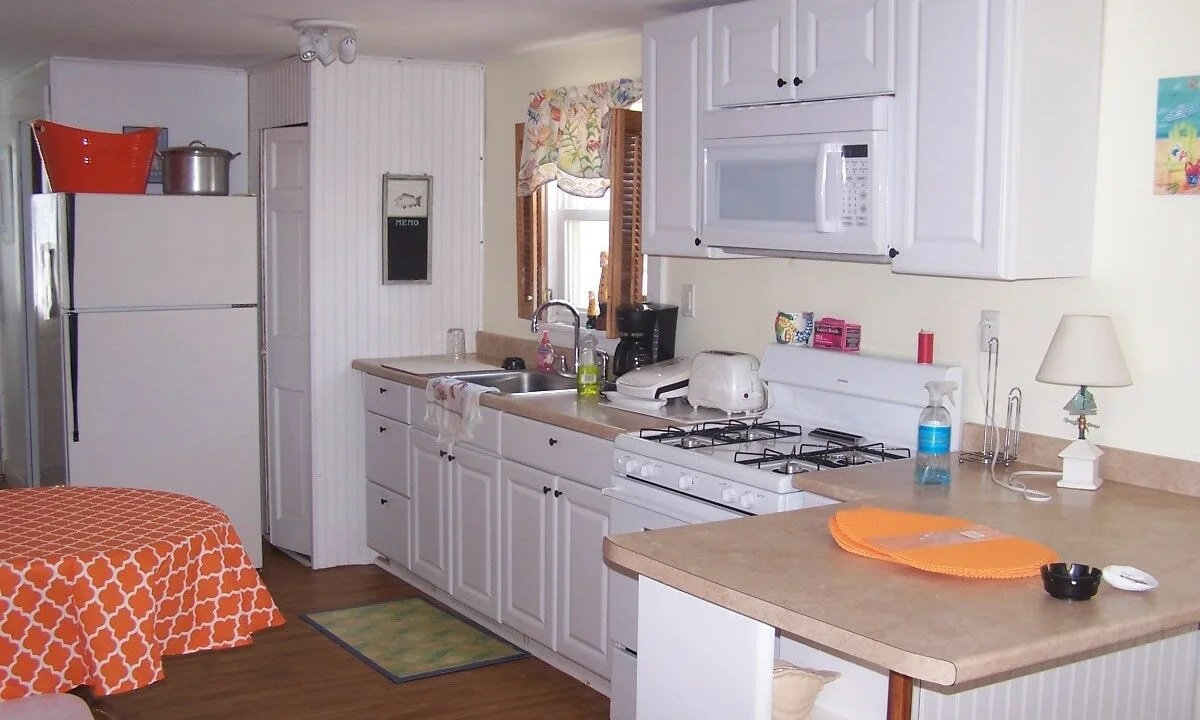 a kitchen with white cabinets and white appliances.