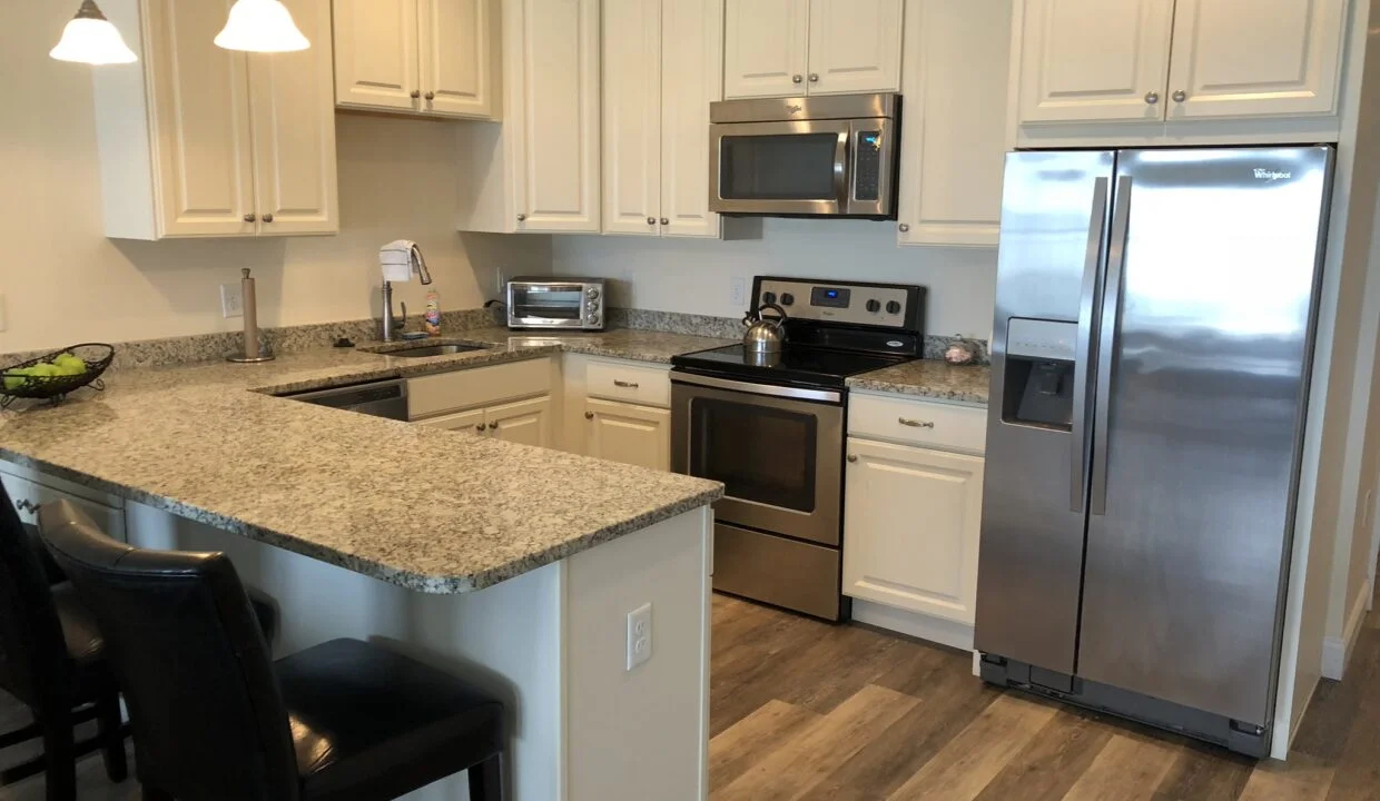 a kitchen with stainless steel appliances and white cabinets.