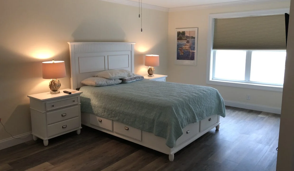 a bedroom with a bed, two nightstands and a ceiling fan.