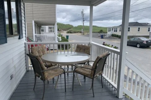 a porch with a table and chairs on it.
