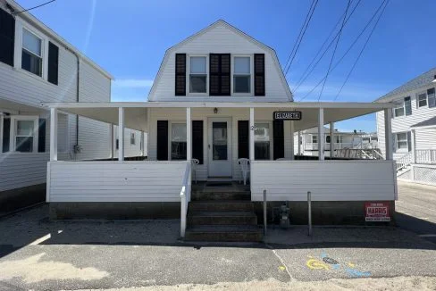 a white two story house with black shutters.