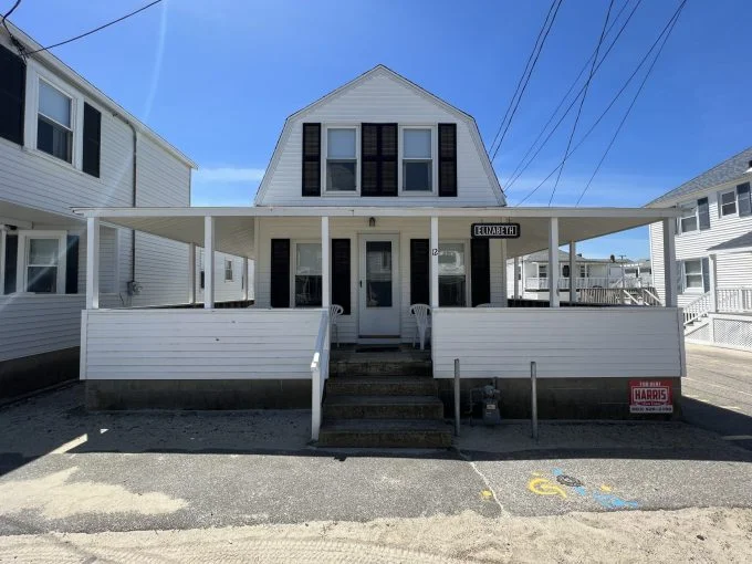 a white two story house with black shutters.