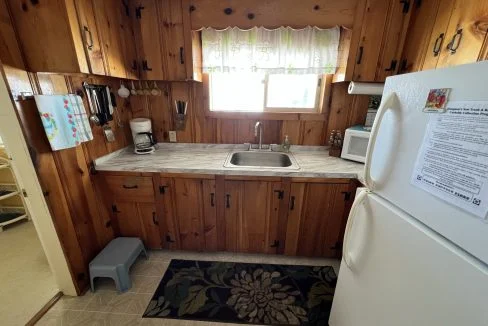 a kitchen with wood paneling and a white refrigerator.