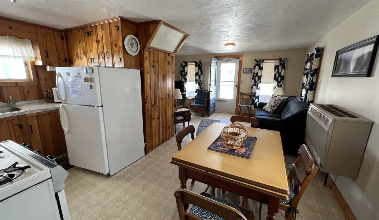 a kitchen with a table, refrigerator and stove.