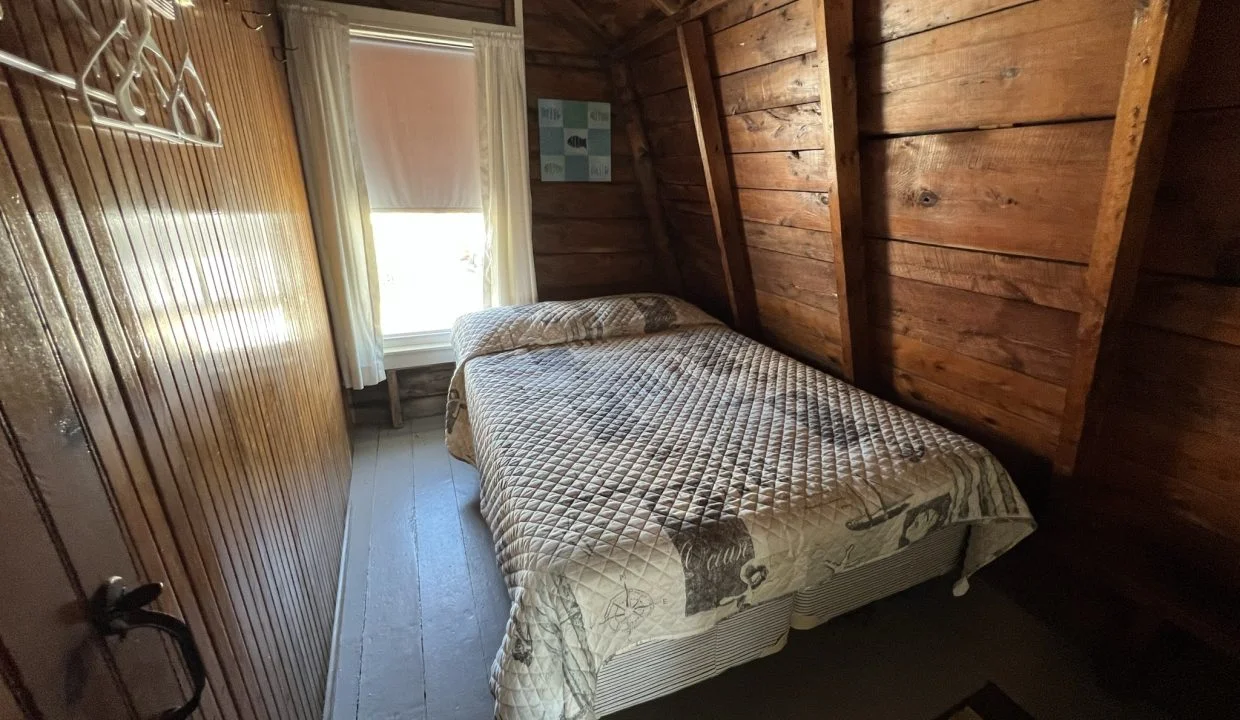 a bed sitting in a bedroom next to a window.