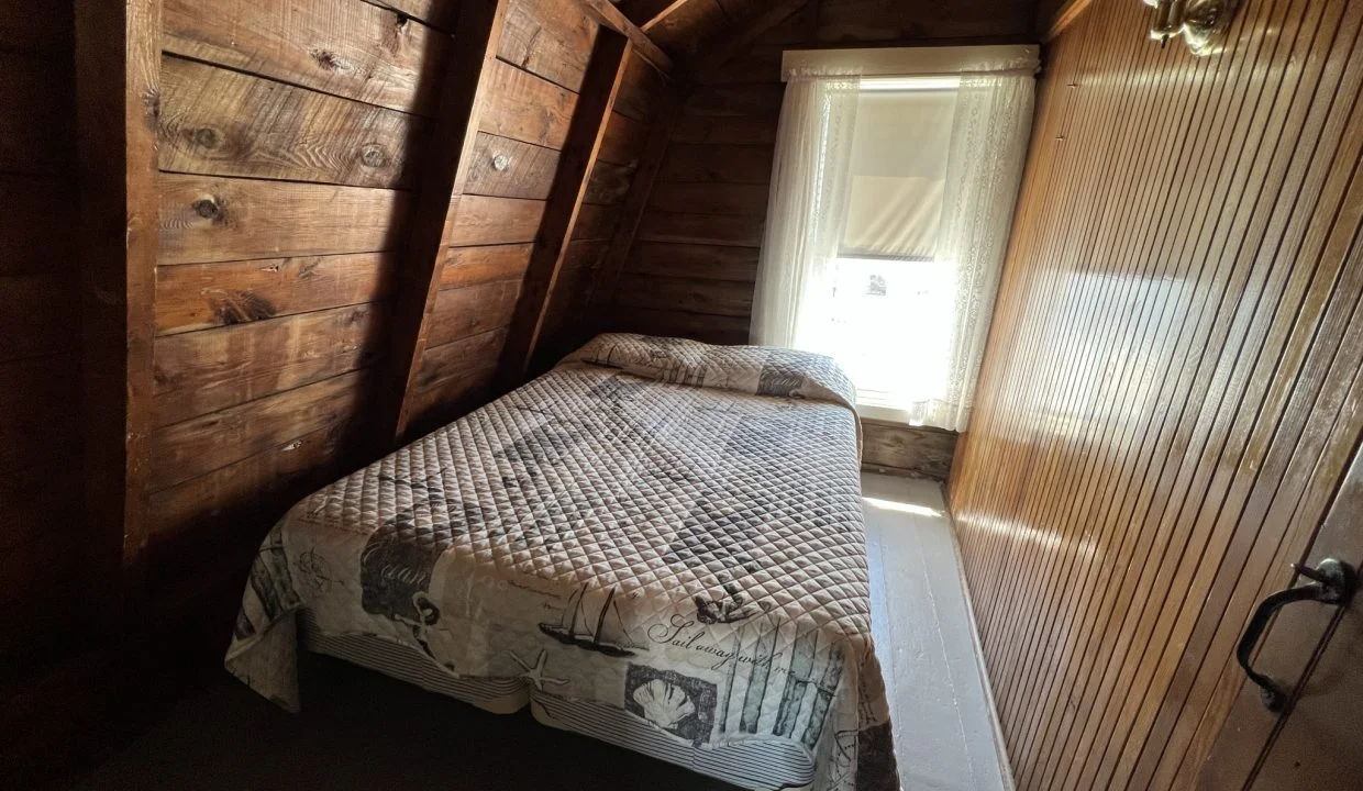 a bed sitting in a bedroom next to a window.