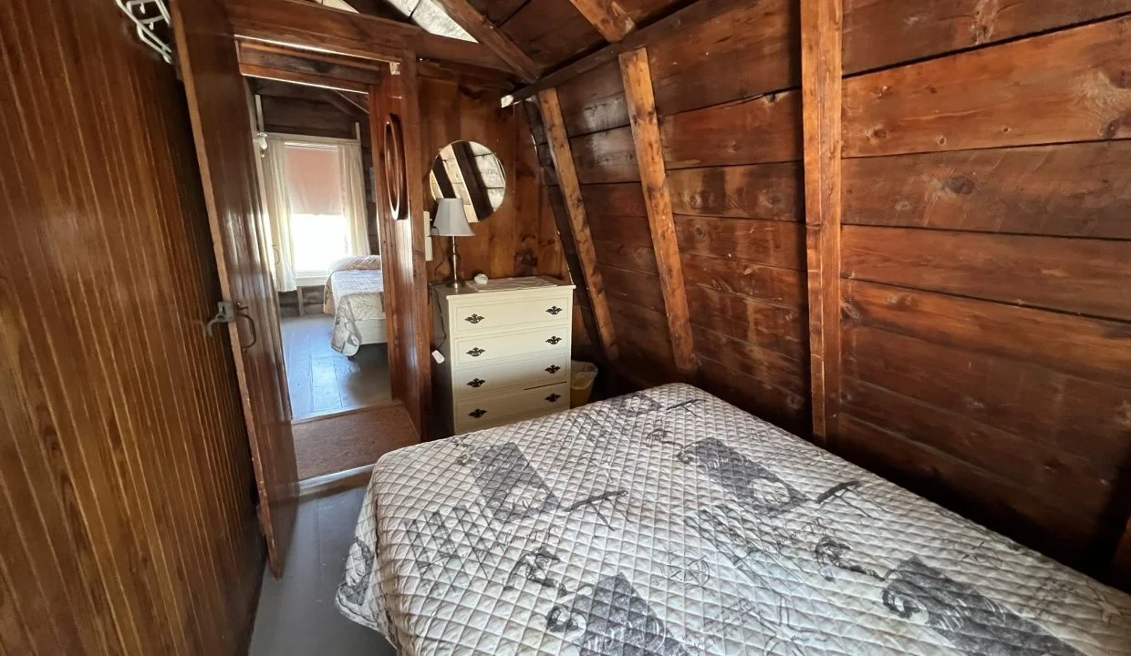 a bedroom with wooden walls and a bed.