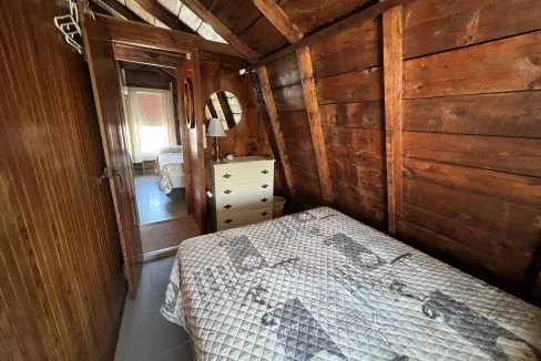 a bedroom with wooden walls and a bed.