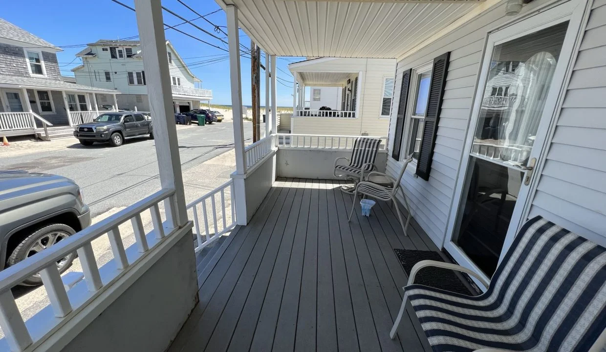 a couple of chairs sitting on top of a wooden porch.