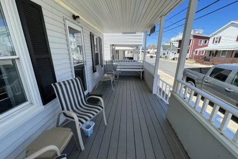 a couple of chairs sitting on top of a wooden porch.