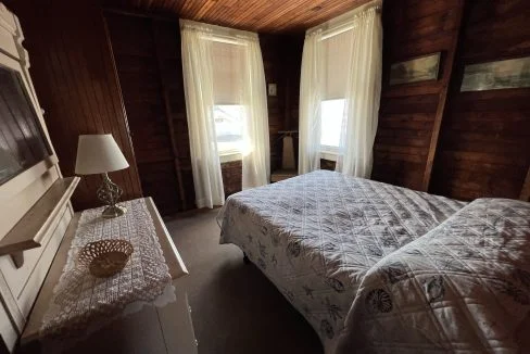 a bed room with a neatly made bed and a dresser.