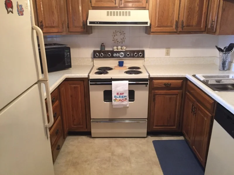 a kitchen with a stove, refrigerator, and microwave.