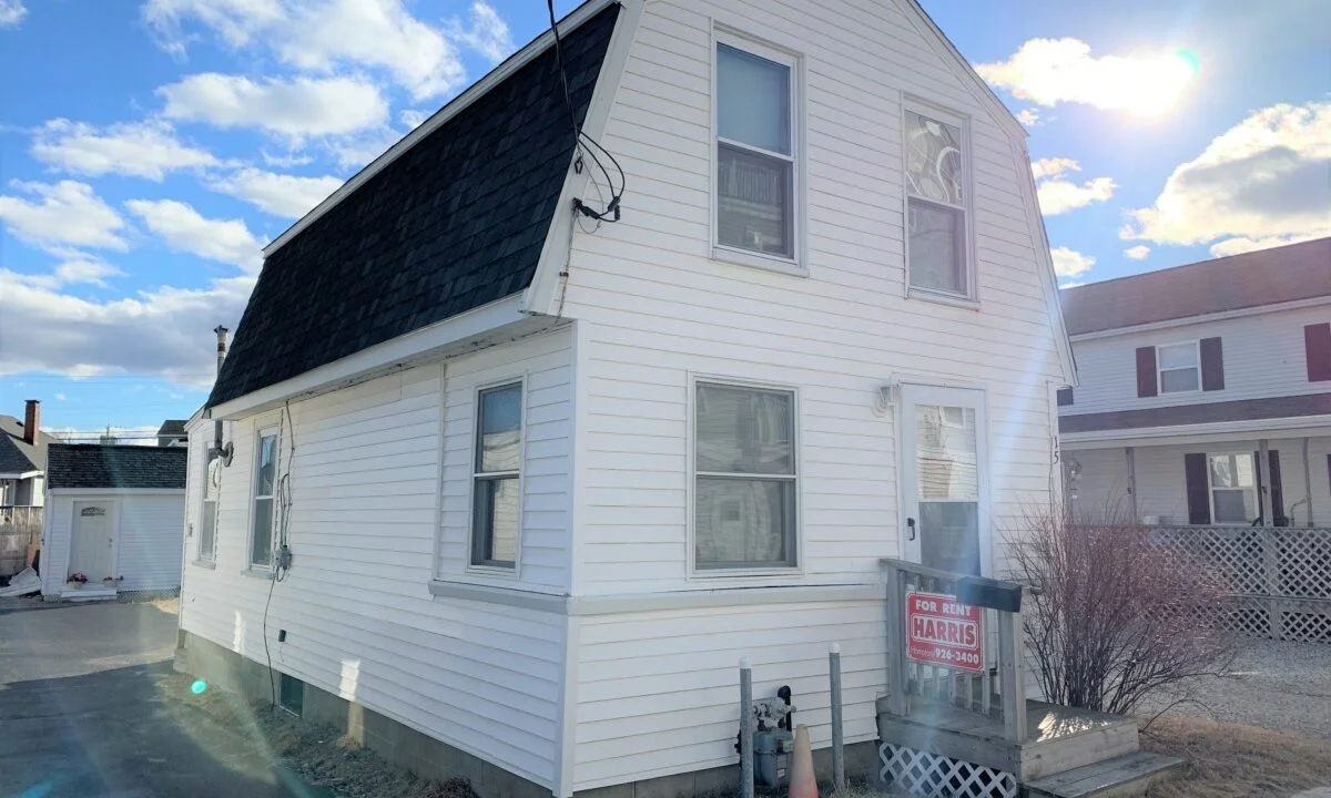 a white two story house with a black roof.