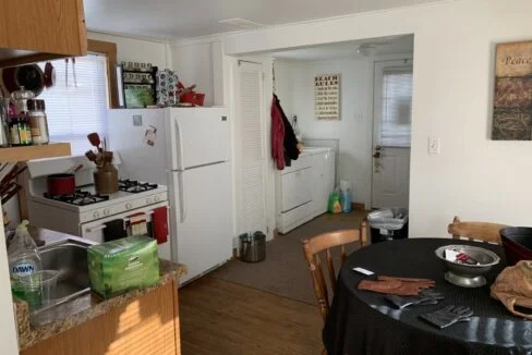 a kitchen with a table and a refrigerator.