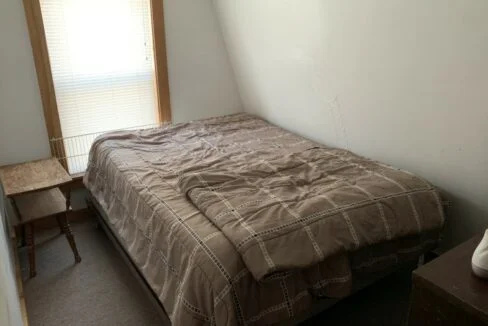 a bed sitting in a bedroom next to a window.