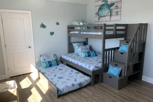 a bedroom with bunk beds and a stair case.