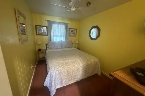 a bedroom with a bed and a ceiling fan.
