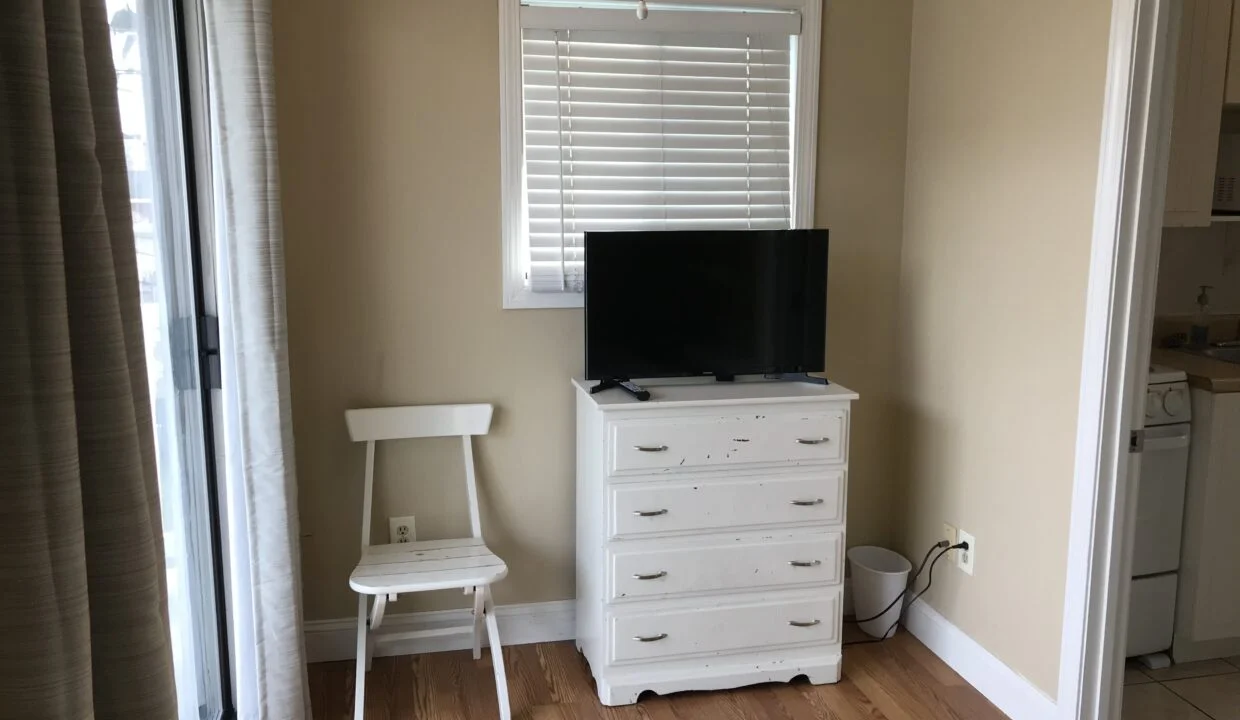 a flat screen tv sitting on top of a white dresser.