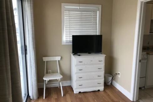 a flat screen tv sitting on top of a white dresser.