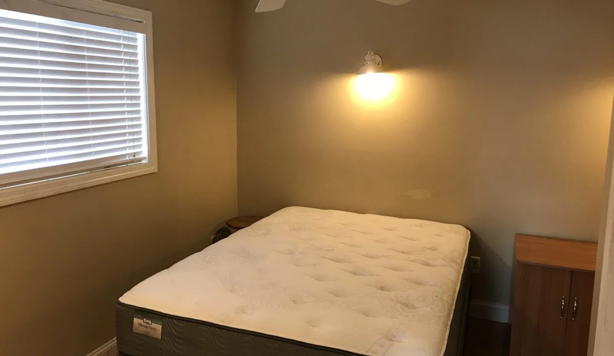 a bedroom with a bed and a ceiling fan.