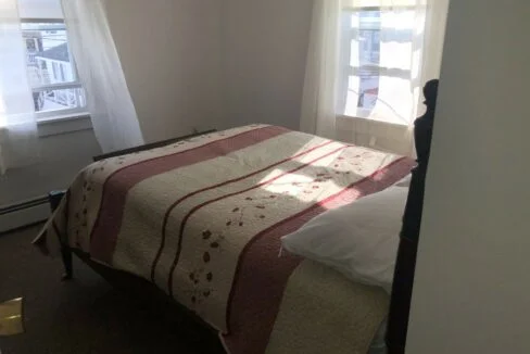 a bed sitting in a bedroom next to a window.