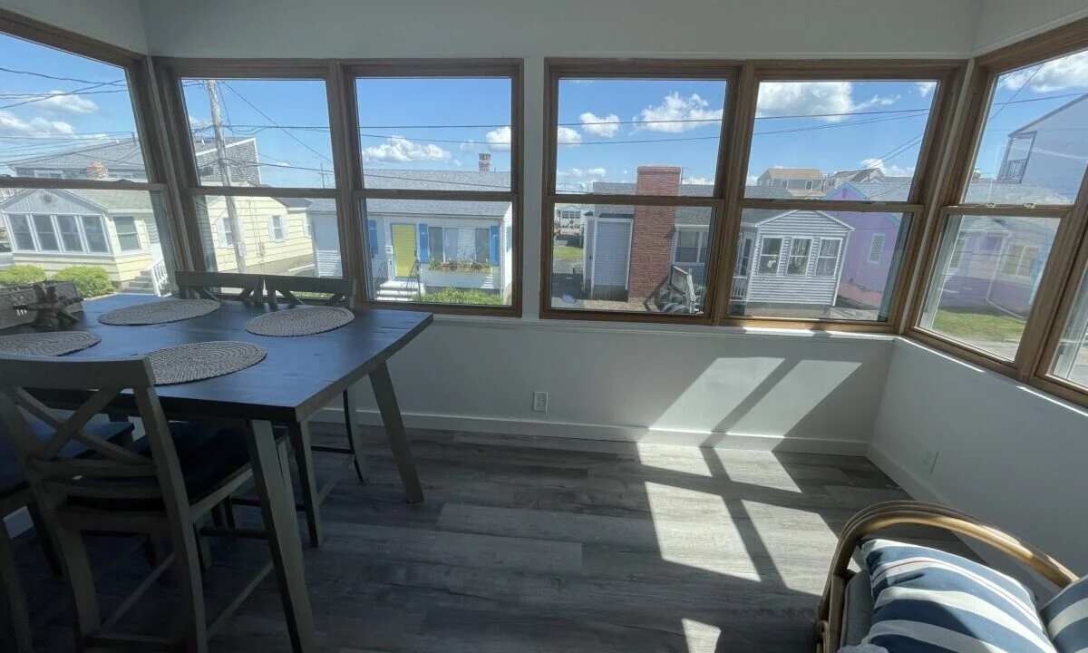 a room with a table, chairs, and windows.