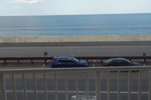 a balcony with a table and a view of the ocean.