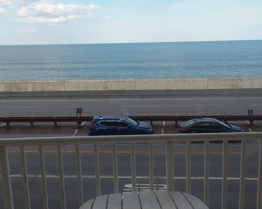 a balcony with a table and a view of the ocean.