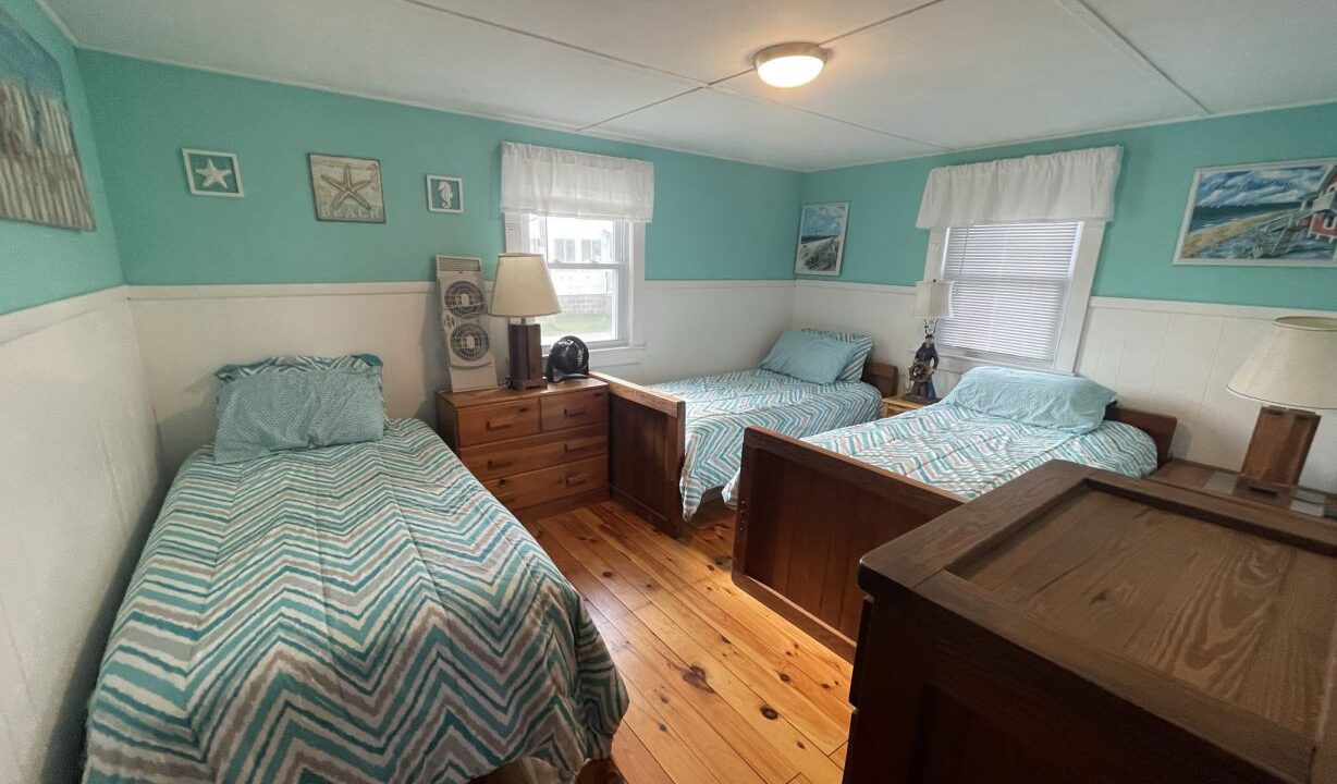 a bedroom with two beds and a dresser.