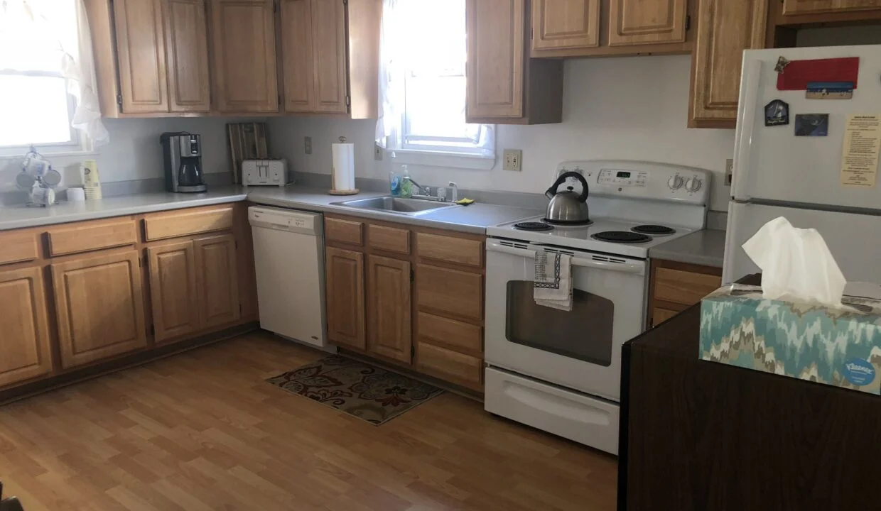 a kitchen with wooden floors and white appliances.