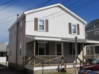 a car parked in front of a two story house.