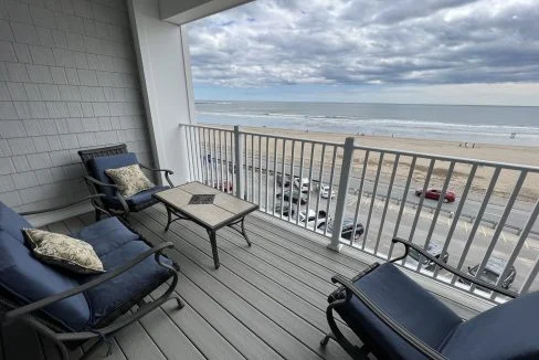 a couple of chairs sitting on top of a wooden deck.