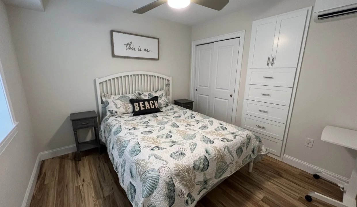 a bedroom with a bed and a ceiling fan.