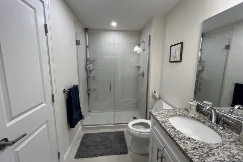 a bathroom with a sink, toilet, and shower.