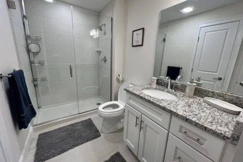 a bathroom with a sink, toilet, and shower.