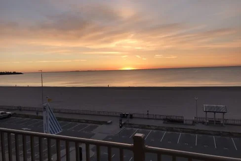 A view of the beach from the balcony of a hotel.