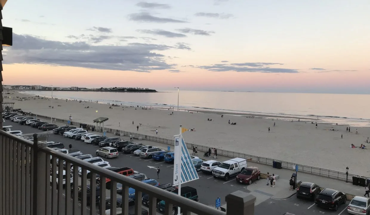 A view of the beach from a balcony at dusk.