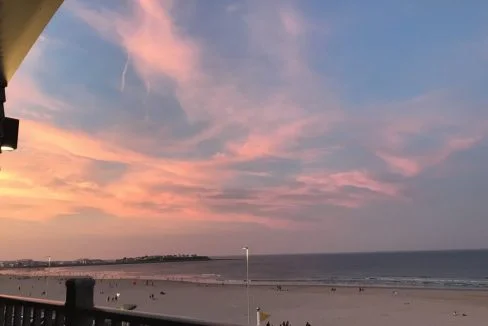 A balcony overlooking the beach at sunset.