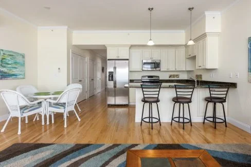 A kitchen and dining area with a bar stools.