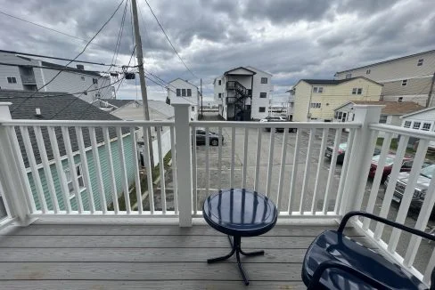 a couple of chairs sitting on top of a wooden deck.