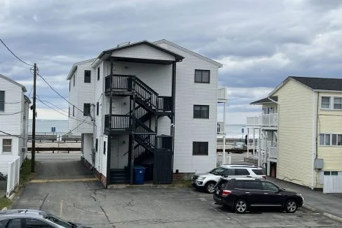 two cars parked in a parking lot next to a building.